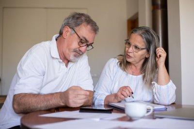 Senior couple reviewing retirement health care and financial planning documents at home